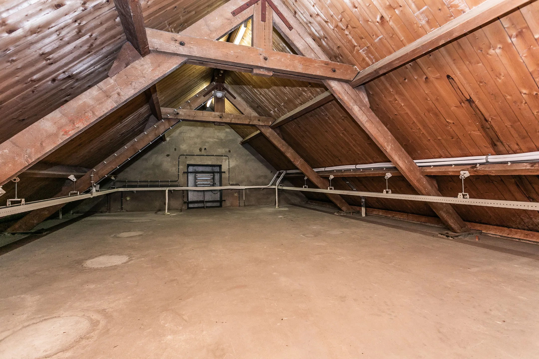 exposed-beam-attic-space-with-wood-ceiling-and-concrete-floor